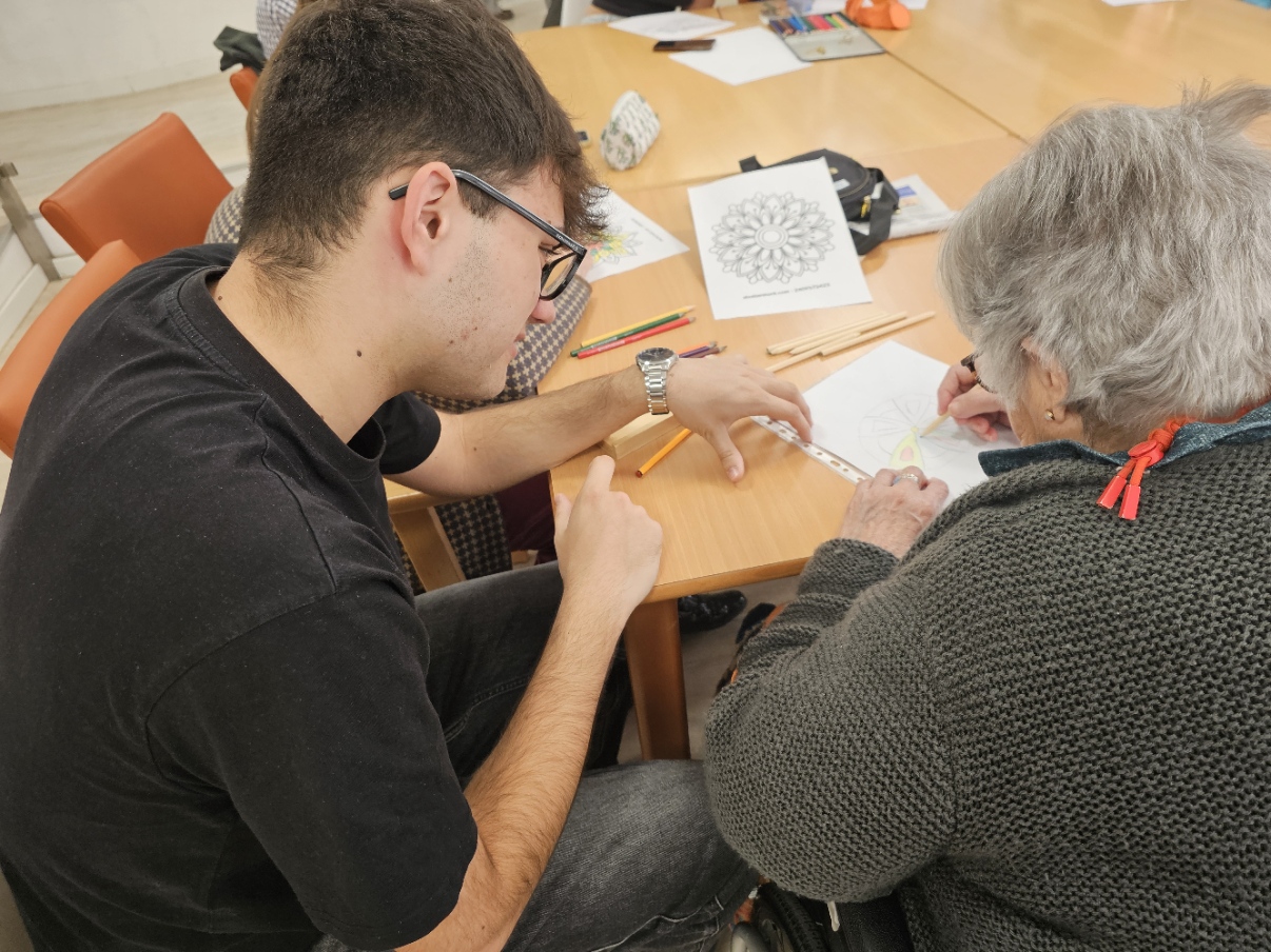 Estudiante y persona mayor coloreando juntos una mandala