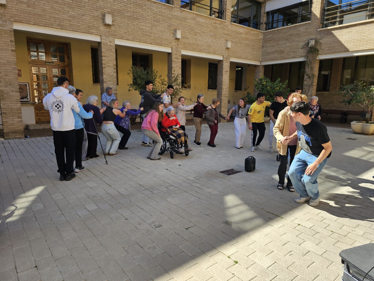 Otro momento de la rueda-cadeneta con mayores y estudiantes bailando